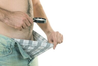 Seorang pria melihat penisnya, ingin memperbesar ukurannya